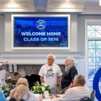 Group of people talking around a table in the Alumni House